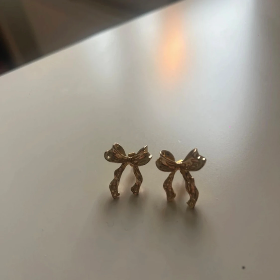 Guldiga örhängen med rosettform