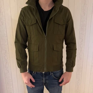 Militärgrön field jacket fashion man  - Väldigt fint skick och en perfekt höstjacka, den sitter liten i storlek så passar en stor S eller M. Modell är 182, hör av dig vid frågor eller intresse. 