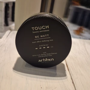 Touch Be Matt vax från Artègo - Matt effekt stylingvax från Artègo, Touch Be Matt. Ger definierad look med medium stadga. Innehåller olivblad, kornextrakt och brasiliansk lera. Kommer i en rund svart burk med skruvlock.