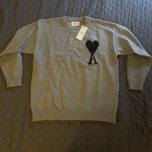 Grå tröja från Ami Paris - ✨ Riktigt bra kvalité – känns lyxig och håller formen 📦 Originalpåse ingår vid köp 👕 Storlek S – passar även M (lite oversized fit) 🇫🇷 Stilren design som funkar till allt 🔥 Helt ny, Skriv vid intresse eller frågor!!