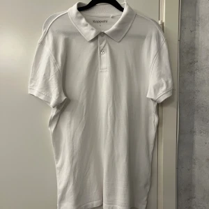 En vit pikétröja från Kappahl  - En snygg vit pikétröja från Kappahl i storlek S. En klassisk piké med krage, den har använts en gång på en skolavslutning annars har den bara hängt i garderoben. Nytt skick, snygg piké som passar när man vill vara lite extra uppklädd. Hör av er om ni har frågor!