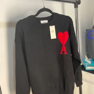 Svart stickad tröja från Ami Paris - Svart stickad tröja från Ami Paris, väldigt stilig tröja. Passar dig som gillar unika plagg.👌