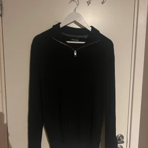 Svart half zip tröja Jack & Jones - Svart långärmad tröja från Jack & Jones med snygg half zip-dragkedja vid halsen. Enkel och stilren design som passar perfekt till jeans eller chinos. Mjuk och skön känsla, perfekt för kyligare dagar.