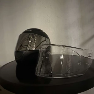 Svart MC-hjälm LS2 FF353 med visir - Säljer en svart MC-hjälm från LS2, modell FF353, med spegelvisir och extra klart visir. Hjälmen har sportig form, ventiler framtill och röd insida. Perfekt för dig som vill ha cool look på hojen. Visiret är lätt att byta och hjälmen har snabbspänne.