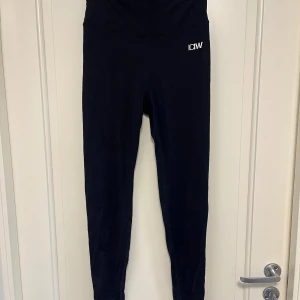 Svarta leggings från ICANIWILL - Svarta leggings från ICANIWILL med hög midja och diskret logga framtill. Tight passform och stretchigt material som passar perfekt till träning. Snygg rynkdetalj bak för extra form. Stilrena och bekväma tights.