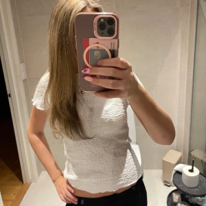 Vit strukturerad topp med kort ärm - Säljer en vit topp med korta ärmar och strukturerat tyg💕