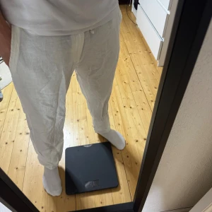 Vita linnebyxor med snörning från Zara - Fräscha vita linnebyxor från Zara med avslappnad passform och snörning i midjan. Byxorna har fickor på sidorna och är perfekta för varma dagar. Materialet är lätt och luftigt linne, vilket gör dem riktigt sköna att bära.