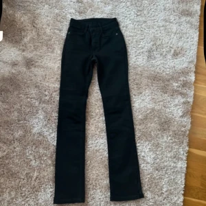Svarta jeans - Svarta jeansbyxor med hög midja och raka ben. Storlek 34