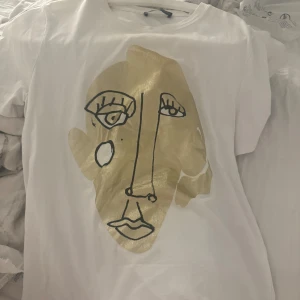 Vit t-shirt med guldtryck från Zara - Vit t-shirt från Zara, säljs inte längre. Jättefin💕