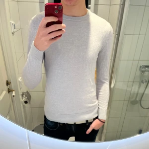Ljusgrå stickad tröja John Henric  - Snygg ljusgrå stickad tröja från John Henric i storlek S. Tröjan är i mycket bra skick och är i 100% merinoull. Modellen på bilden är 180 cm lång o väger 75 kg. Hör av er vid funderingar och frågor!