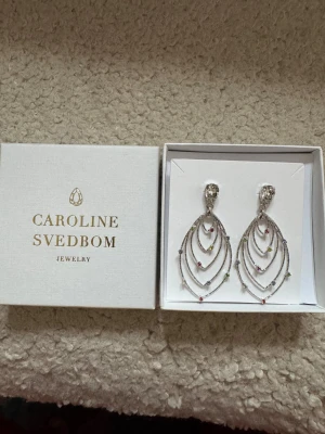 Caroline Svedbom örhängen - Säljer mina älskade caroline svedbom örhängen då de aldrig kommer till användning, endast använda 1 gång! Så himla fina till festligare tillfällen såsom nu till jul och nyår ❤️‍🔥😍😍🕺🏽💖 PERFEKT JULKLAPPSTIPS!!! nypris ca 1200 säljer för 800! 
