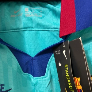 Blå FC Barcelona långärmad matchtröja - Snygg FC Barcelona långärmad fotbollströja från Nike i ljusblå färg med geometriskt mönster. Tröjan har klubbmärke på bröstet, Rakuten-tryck och detaljer i mörkblått och rött vid kragen. Tillverkad i lätt och ventilerande polyester med Dri-Fit teknologi. Pris går att diskutera.