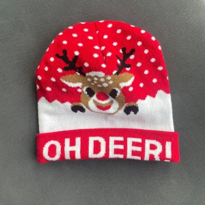 Röd och vit julmössa med renmotiv - Säljer en riktigt söt julmössa i rött och vitt med snöprickar och ett gulligt renmotiv framtill. Texten 'OH DEER!' syns på uppviket. Mössan är stickad i mjukt material och passar perfekt för att maxa julstämningen.