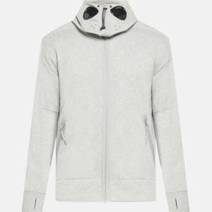 Ljusgrå vindjacka från C.P. Company - Säljer en ljusgrå ziphoodie från C.P. Company den är väldigt tjock o varm, Nyskick använd några få gånger Storlek M passar L