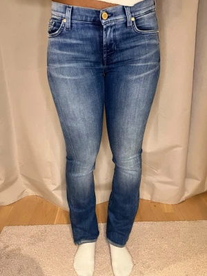 Blå jeans från 7 For All Mankind - Snygga blå dam jeans från 7 For All Mankind med klassisk femficksdesign och diskreta slitningar. Jeansen har en bootcut passform med normal midja och är tillverkade i mjukt denimtyg. Perfekta för dig som gillar en tidlös och clean look. Jeansen är i extremt bra skick och nypris ligger på cirka 2000-3000kr vårt pris 650kr😊 hör av er vid frågor eller andra pris förslag✅ postar samma dag/ grabbarna på studio II Resell