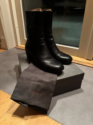Svarta stövletter från Vagabond i skinn - Säljer ett par svarta stövletter från Vagabond i mjukt skinn. Modellen har rund tå, blockklack och guldfärgade dragkedjor baktill. Skorna är stilrena och passar perfekt lika bratill höst och vinter som nu till våren. Kommer med originalpåse och låda.