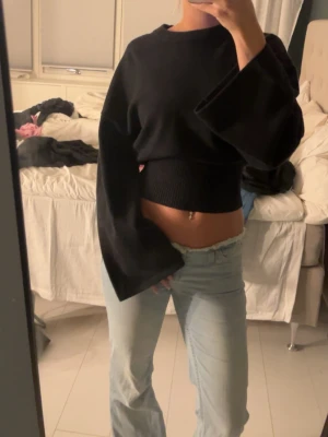 Svart stickad tröja med vida ärmar - Säljer en svart stickad tröja från gina med vida ärmar och kroppad pasform! Aldrig använd men ingen prislapp kvar 