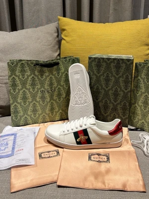 Gucci Ace skor  - Säljer ett par vita Gucci Ace sneakers. Dem rö helt nya blev för med str i julklapp, aldrig använda kvitto finns. OBS!! Str är lite liten för 45 