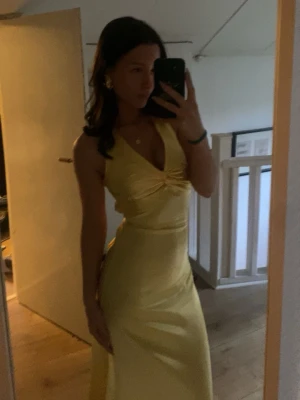 Gul balklänning med öppen rygg - Säljer en snygg gul långklänning storlek:S. Klänningen har v-ringning, knyt i ryggen och dold dragkedja samt öppen rygg med korsade band. Perfekt för balen eller bröllopsgäst. 