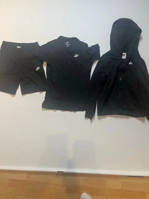 Svart Nike zip hoodie, svart Nike T-shirt och svarta Nike shorts alla med storlek 147-158cm - Svart Nike zip hoodie, svart Nike T-shirt och ett par svarta Nike shorts och alla har storleken 147-158cm