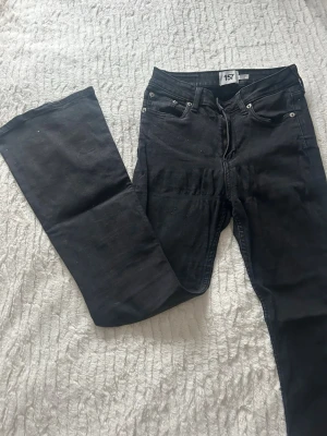 Svarta flare jeans från 157, storlek S - Svarta jeans från 157 i modellen Snake Flare, storlek S med kort benlängd. Byxorna har klassisk femficksdesign, dragkedja och knapp framtill. Materialet är jeans och passformen är utsvängd nertill för en cool flare-look.