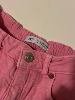 Neonrosa shorts från Zara - Säljer ett par ljus/neonrosa shorts från Zara med fransade kanter. Perfekta för varma dagar och har en chill loose passform. Använts flitigt men fortfarande i väldigt fint skick! 
