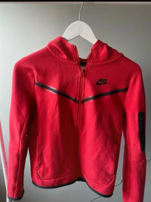 Nike tech fleece röd  - Jag säljer en röd Nike tech fleece som är i ett väldigt bra skick. Priset kan diskuteras. Skickas samma eller nästa dag som köpet gjorts.