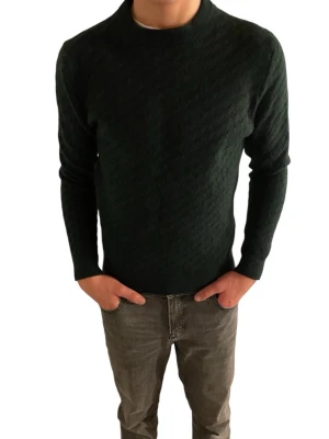 Mörkgrön stickad tröja från H&M - Mörkgrön stickad tröja från H&M. Tröjan har diskret strukturmönster, rund halsringning och ribbade muddar vid ärmslut och nederkant. Perfekt för kyliga dagar och enkel att matcha med jeans.