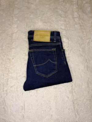 Jacob Cohën Bard Jeans – Made in Italy – Size 32 – Lyxdenim - Säljer ett par Jacob Cohën Bard jeans i storlek 32/32, äkta lyxdenim handgjorda i Italien 🇮🇹  Jeansen är i näst intill nytt skick, sparsamt använda och utan slitage. Kvaliteten känns direkt – exklusiv denim, perfekta sömmar och ikoniska detaljer.  🔹 Modell: Bard 🔹 Storlek: 32/32 🔹 Färg: Mörkblå 🔹 Skick: Näst intill nytt 🔹 Made in Italy 🔹 Äkta – QR-tag & originaletiketter finns (se bilder)  Nypris är betydligt högre. Perfekt för dig som vill ha premiumjeans i toppskick till ett klart bättre pris. 