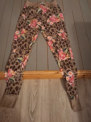 Underställ  med leopard och blommor - Snygga underställsbyxor från Blount & Pool i storlek 38. Byxorna har ett leopardmönster med stora rosa och orange blommor, samt beige muddar vid midja och benslut. Perfekta för dig som vill sticka ut med färg och mönster! Säljer då de är försmå för mig som 167cm lång