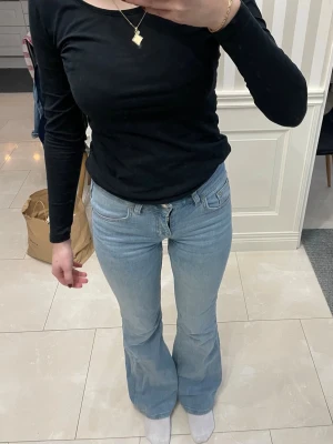 Ljusblåa jeans - Ljusblåa bootcut jeans med low/mid waist. Lite slitage längst ner men inget som märks!
