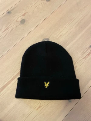 Lyle and Scott mössa - Svart lyle and skott mössa. Köpt ny för 295kr.  Inga skador 