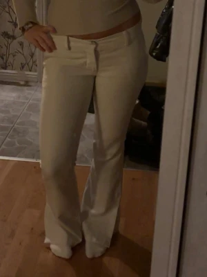 Vita bootcut jeans låg midja - Säljer ett par vita bootcut jeans med låg midja. Snygg passform som sitter tajt upptill och släpper ut vid bensluten. De är från Bik Bok i modell Vera med slits vid benen 🥰