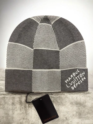 LV Damier Heritage Mössa | Grå | One Size - Designer mössa i rutigt mönster, grå  Storlek: One size  Mössa med Damier-mönster och logodetalj. Vanlig modell för vardagsbruk och perfekt för kallare årstider. Skickas inom 24 h!