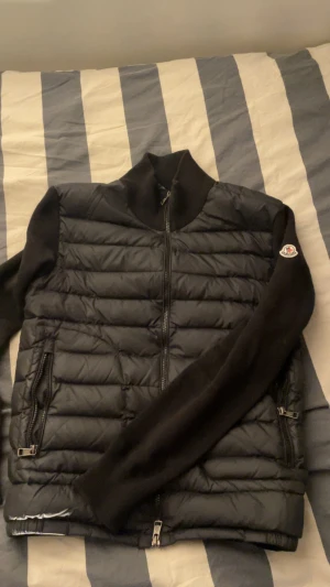 Moncler Cardigan - Svart cardigan från Moncler. Har ett litet hål, skriv för mer information. Den passar folk i storlek S och M. Vill sälja den så fort som möjligt så pris kan diskuteras.