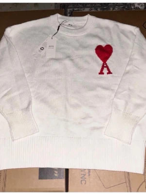 Ami paris - Jätte fin tröja som är vit och har ett rött märke vid sidan där framme. Den är jätte skön och ha på sig. Pris kan diskuteras