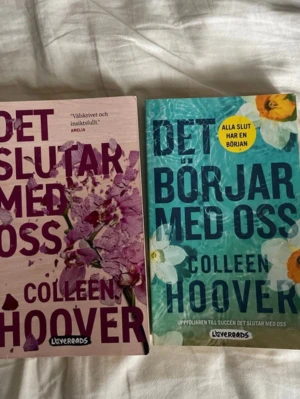 Det slutar med oss & Det börjar med oss - Två skönlitterära romaner av Colleen Hoover: 'Det slutar med oss' med rosa omslag och blommotiv samt 'Det börjar med oss' med turkost omslag och vita blommor. Båda böckerna är tryckta i mjukpärm och utgivna av Lovereads.