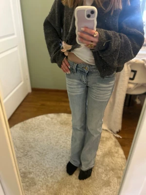 Ljusblå bootcut jeans från Cheap Monday - Säljer ett par ljusblå jeans från Cheap Monday med bootcut passform och klassisk femficksdesign. Jeansen har en grön logga bak och är tillverkade i mjukt denimtyg. Perfekta för en avslappnad och trendig look.