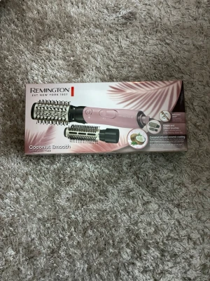 Remington varmluftsborste - Remington Coconut Smooth varmluftsborste i ljusrosa med keramisk beläggning infuserad med kokosolja. Inkluderar två utbytbara borstar. Aldrig använt bara öppnat förpackningen och kollat!!!
