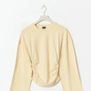 Ljus gul långärmad topp med snörning - Superfin ljus gul långärmad topp från gina tricot med snygg snörning i sidorna som ger en cool rynkad effekt. Modellen är croppad och har en relaxed fit i ärmarna. Perfekt att styla med jeans eller kjol för en chill look. Skriv hjärna vid fler frågor eller pris och även inte andvänt, köpte för 300kr