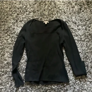 Svart ribbad långärmad tröja H&M - Svart långärmad tröja från H&M med ribbad struktur och fyrkantig ringning. Sitter snyggt och har en enkel, stilren look som passar till mycket. Perfekt att matcha med jeans eller kjol för en clean vibe.