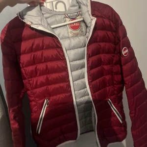 Colmar jacka - Vinröd dunjacka, tunn och bra till träning. Köpt på Sellpy. Storlek 34-36 (xs-s) passar bra. Bra skick inga deffekter eller så, dragkedjan är ny!