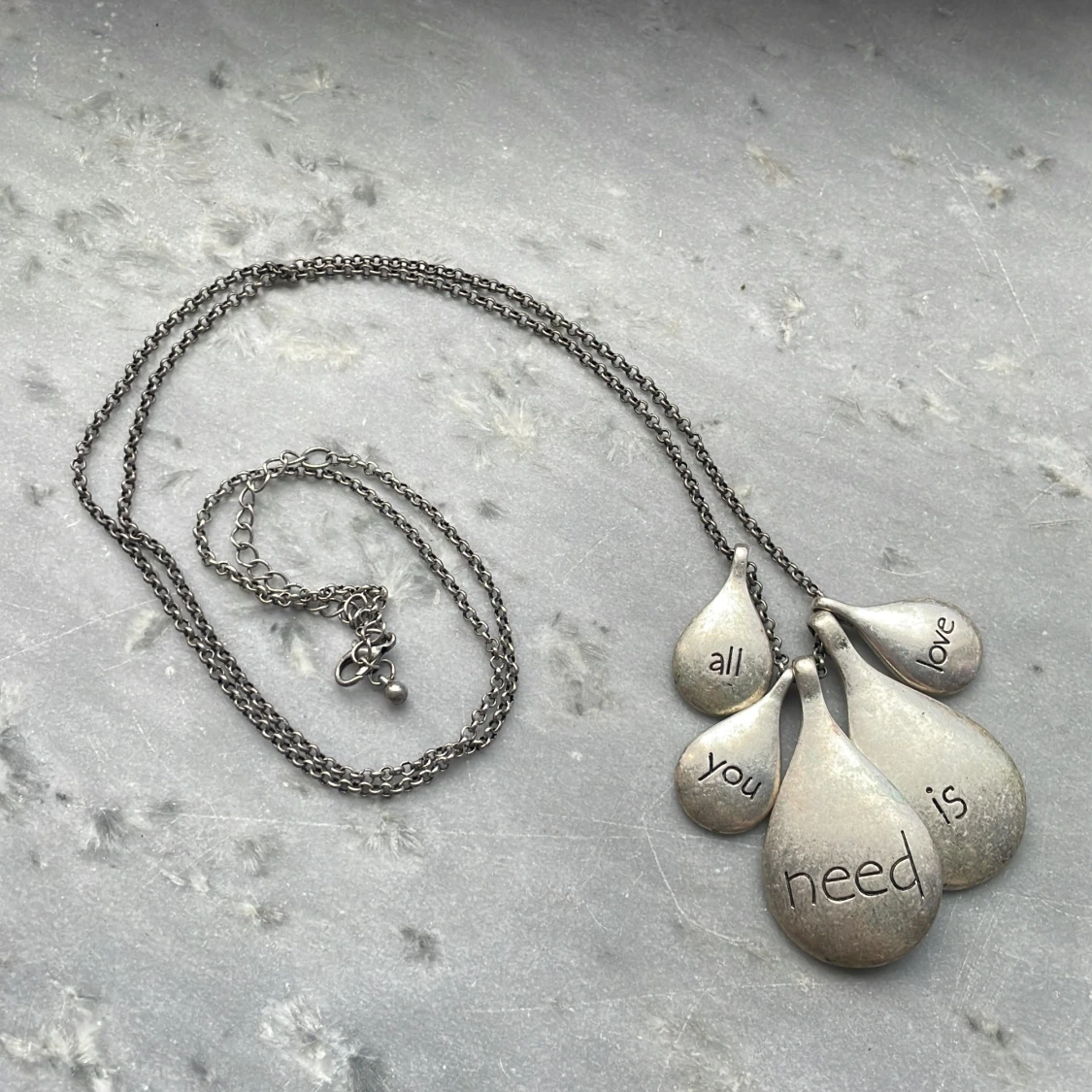 Silverfärgat halsband med berlocker