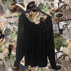 Svart blus med rosett från Ellos - Säljer en svart blus från Ellos i storlek 42/44. Blusen har lång ärm, bred urringning och en söt rosettdetalj vid axeln. Materialet är mjukt och känns som bomull, perfekt för dig som gillar en chill och stilren look.