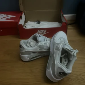 Nike Air Max 90 Gore-Tex vita sneakers - Helt nya och oanvända Strlk 41. Nike Air Max 90 Gore-Tex sneakers i vitt och ljusgrått med svarta detaljer och grön sula. Skorna har klassisk Air Max-dämpning, snörning och är tillverkade i syntet och skinn. Perfekta för dig som vill ha stilrena och vattentåliga sneakers med modern vibe. Pris kan diskuteras 