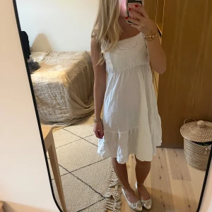 Vit somrig kortklänning med volang - Superfin vit kortklänning med volangkant och broderade detaljer upptill. Jättefint skick och aldrig använd! Skriv för eventuella frågor, priset kan diskuteras! ❤️