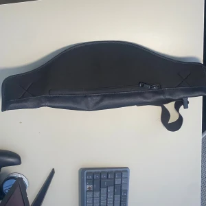 Svart midjeväska från Lacoste - Snygg svart midjeväska från Lacoste med klassisk krokodillogga på framsidan. Väskan har en stilren, böjd form och är tillverkad i slitstark syntet med justerbart band och dragkedja. Perfekt för att bära dina essentials när du är på språng.