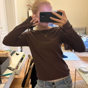Brun ribbad långärmad tröja - Säljer en brun långärmad tröja med ribbad struktur. tröjan har en enkel och stilren design med rund halsringning och sitter snyggt på kroppen. perfekt att matcha med jeans eller kjol för en chill look nu till hösten!!🙌🤎