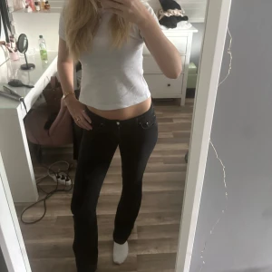 Svarta lågmidjade bootcut jeans - Snygga svarta jeans med låg midja och bootcut passform. Jeansen har klassisk femficksdesign och sitter tajt över låren för att sedan bli vidare nedtill. Perfekta för en trendig och avslappnad look. Jag är för lång för byxorna så därför ser dom tajta ut. Jag är 168🥰