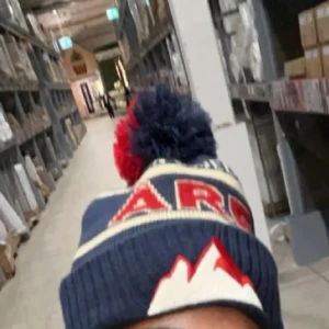 Blå och röd åre mössa med tofs och bergmotiv - Säljer en stickad blå åre mössa med stor tofs i blått och rött. Mössan har ett coolt bergmotiv framtill och text i rött och vitt. Perfekt för kalla dagar och snygg detalj till vinterlooken.